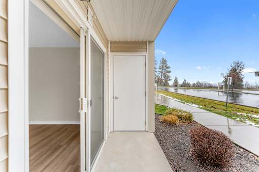 A view of a balcony with a glass door and a white door.