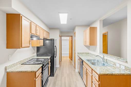 A kitchen with black appliances and wooden cabinets.