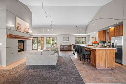 A modern kitchen with a grey couch and wooden cabinets.