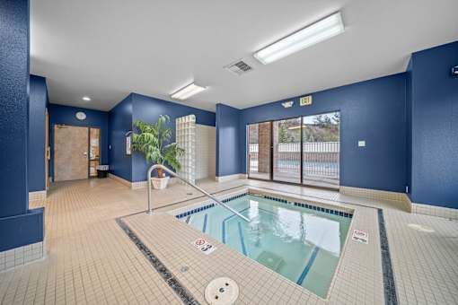 A large indoor swimming pool with a tiled floor and walls.