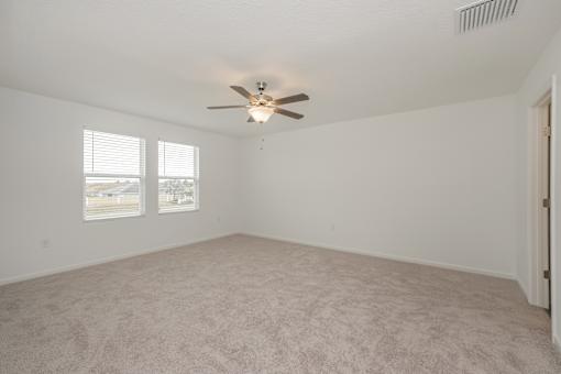 A room with a ceiling fan and carpeted floor.