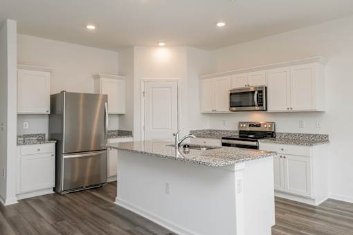 Ruskin, FL Homes - Ruskin Reserve Luxury Kitchen with white cabinets wooden floors granite countertops
