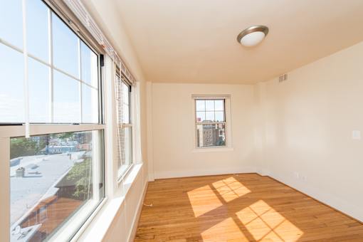 A room with a window and wooden floors.