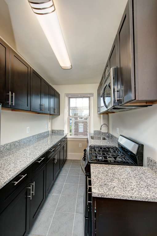 A kitchen with black cabinets and granite countertops.