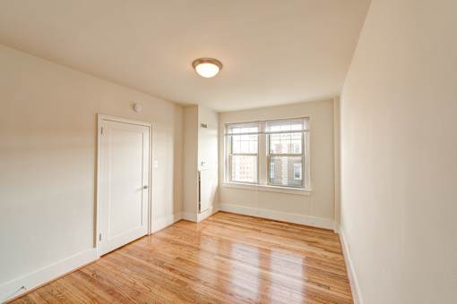 A room with a wooden floor and a window.