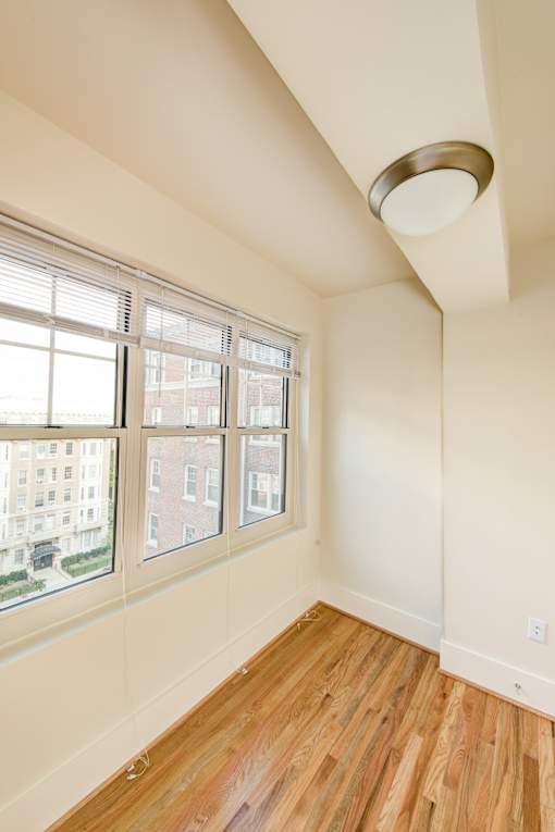 A room with a window and wooden floors.