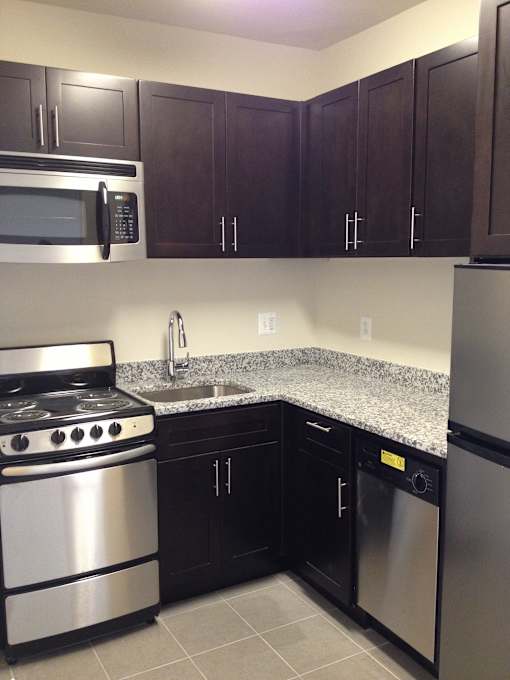 A kitchen with a stove, microwave, and refrigerator.