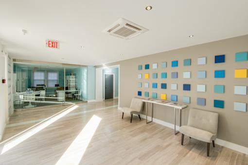 A room with a white wall and a blue and yellow square pattern on the wall.