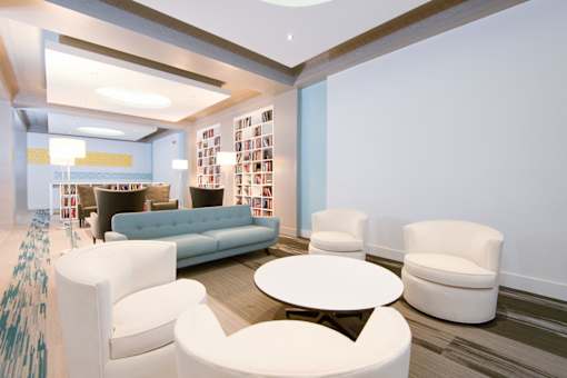 A living room with a white sofa and chairs.