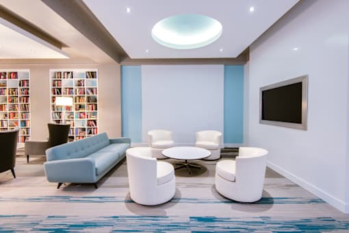 A modern living room with a blue couch and a television.