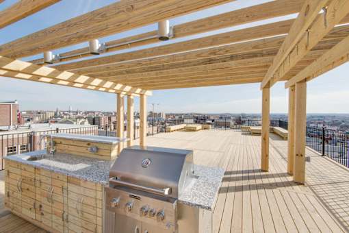 A wooden deck with a grill and a table.