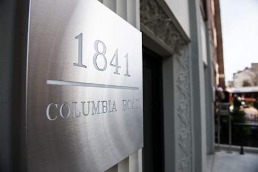 A sign for Columbia Road is displayed on a building.