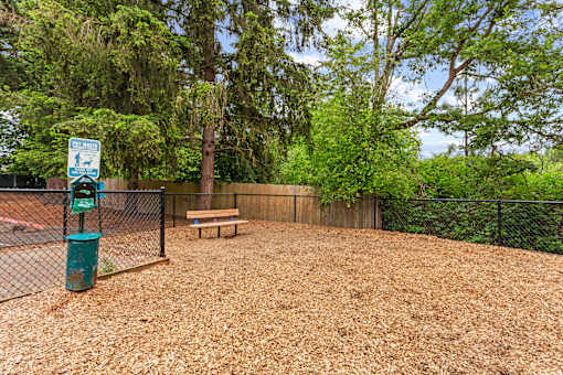 A dog park with a sign and a bench.