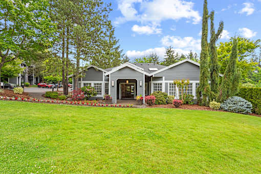 A house with a grey roof and a green lawn in front.