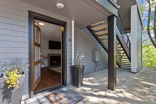 A white house with a wooden door and a staircase.