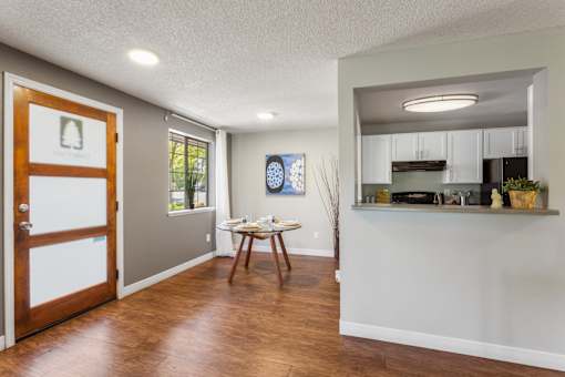A kitchen area with a dining table and chairs.
