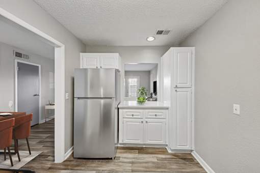 Pet-Friendly Apartments in Sandy Springs– Celebration at Sandy Springs – A kitchen with a refrigerator, cabinets, and a dining table.
