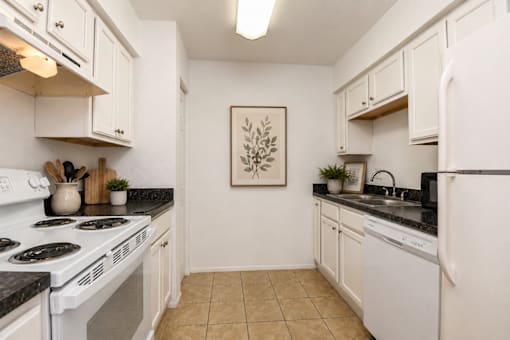 A kitchen with white appliances and cabinets.