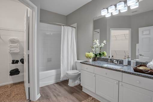 A bathroom with a toilet, sink, and mirror.