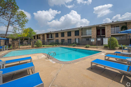 our apartments offer a swimming pool and a patio with blue benches
