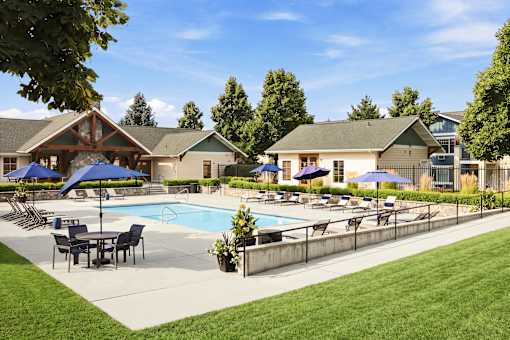 A pool surrounded by lawn chairs and umbrellas.