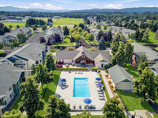 A bird's eye view of a residential area with houses, a swimming pool, and a car.