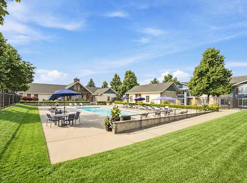 A sunny day at a residential area with a pool and a fence.
