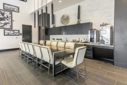 A coffee bar with a table and chairs and coffee machines and sink