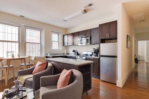 A kitchen with a refrigerator, stove, and sink.