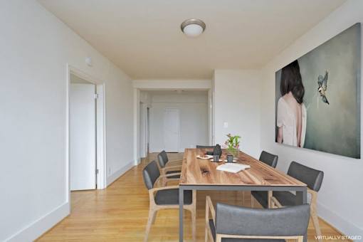 A dining room with a wooden table and chairs.