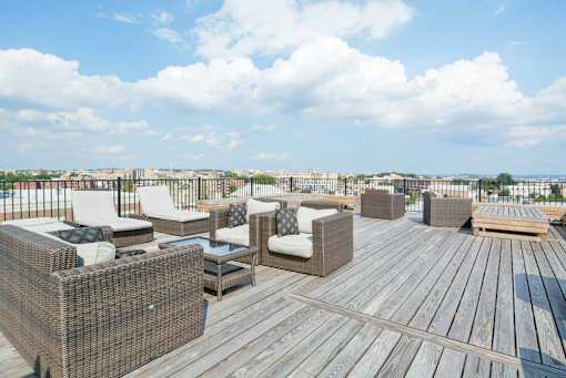 A wooden deck with wicker chairs and a table.