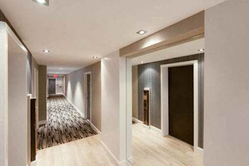 A long hallway with a carpeted floor and white walls.