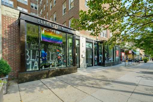 A storefront with a rainbow flag in the window.