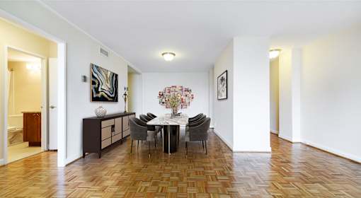 A dining room with a table set for four.