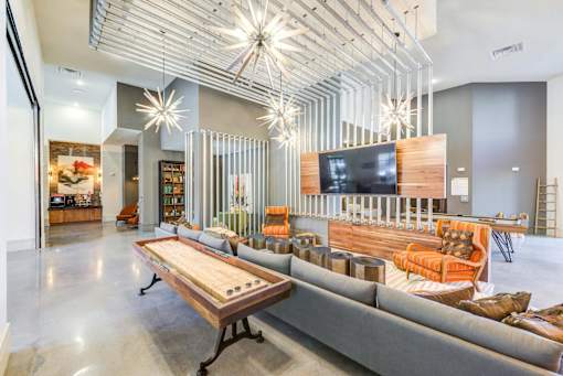 A modern living room with a wooden table and grey couch.