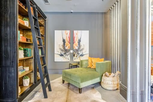 A room with a green chair and a painting on the wall.