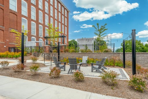 a patio with chairs and a table in front of a building
