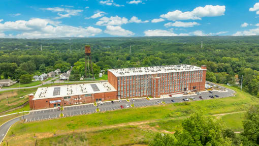 an aerial view of a brick building next to a parking lot
