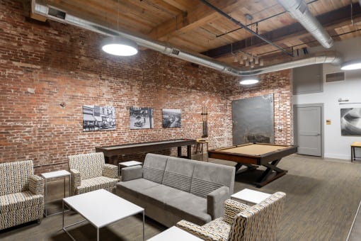 a game room with a pool table and a brick wall