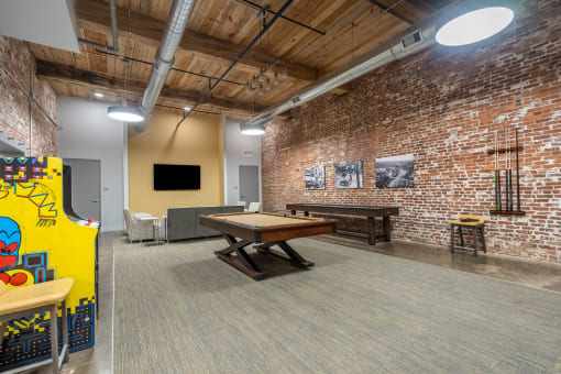 a game room with a pool table and a brick wall