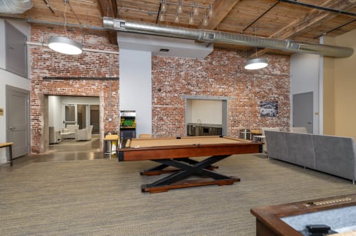 a game room with a pool table and a brick wall