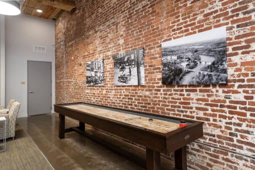 a pool table in a room with a brick wall
