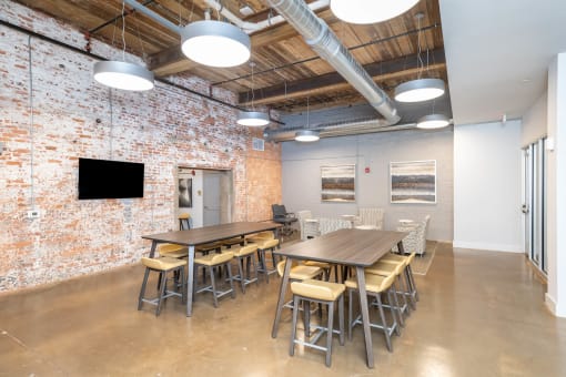 a large conference room with tables and chairs and a brick wall
