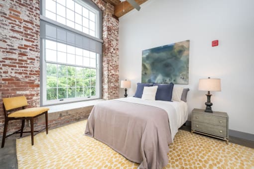 a bedroom with a bed and a large window