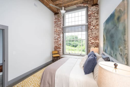 a bedroom with a bed and a large window