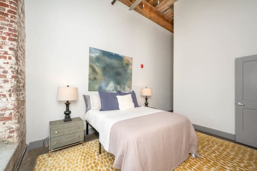 a bedroom with a bed and a painting on the wall