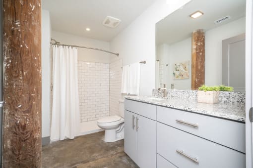a white bathroom with a shower and a toilet