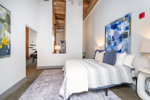 a bedroom with a bed and a view of a living room