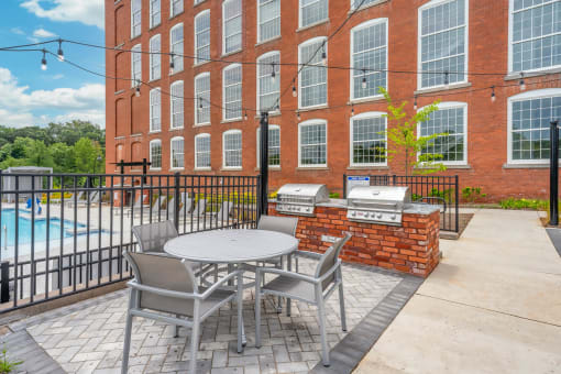 a patio with a table and chairs next to a swimming pool