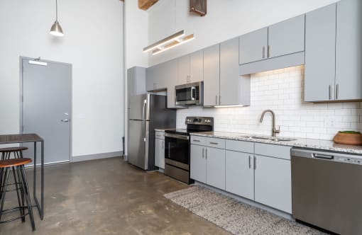 a kitchen with white cabinets and stainless steel appliances